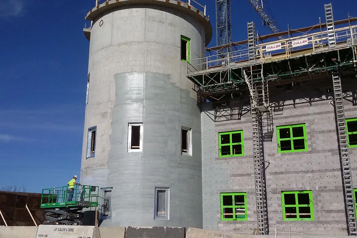 coatings being applied to a large cylinder shaped building