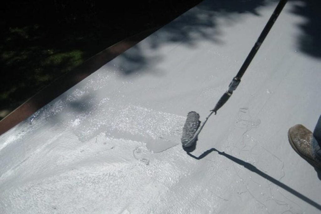 worker applying coatings to a roof