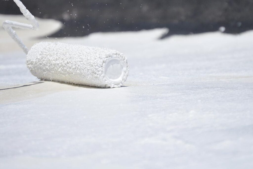 roller brush being placed down on a surface with coating on it