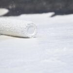 roller brush being placed down on a surface with coating on it