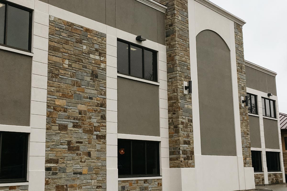 Building with EIF siding interspersed with other types of siding