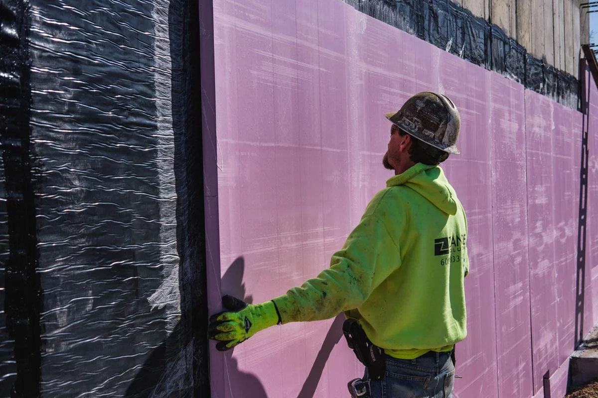 Zander employee applying waterproofing membrane to wall