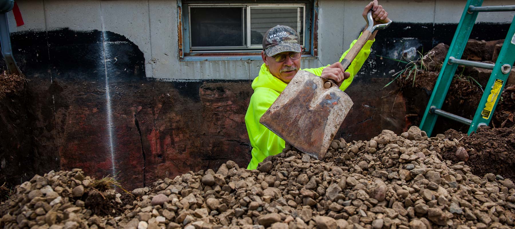 Zander employee shoveling out a window well