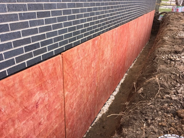 a trench along a wall with panels on the wall