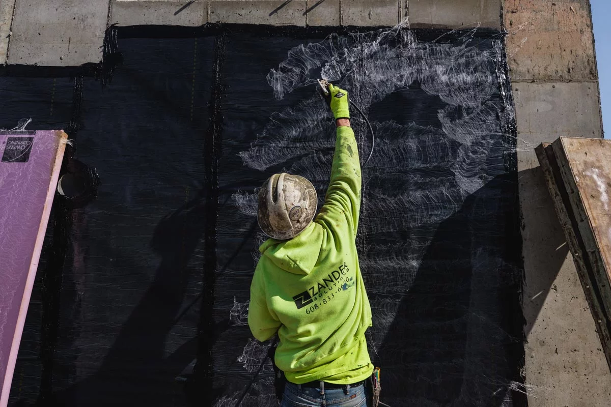 Zander employee applying adhesive to a wall