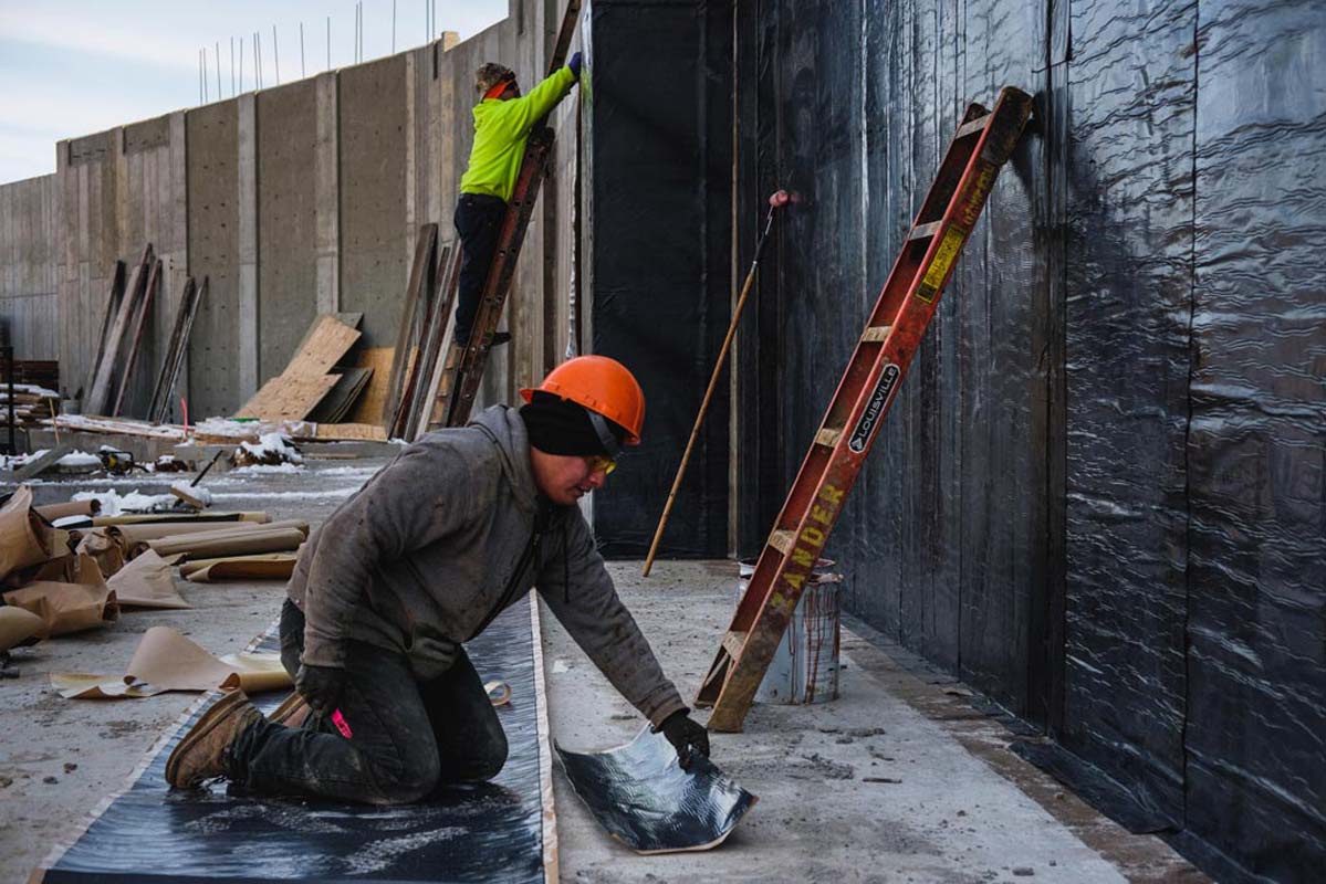 Zander employees working on a wall