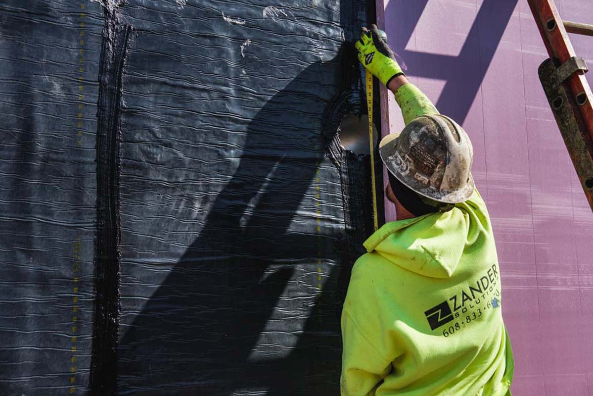 Zander employee working on a wall