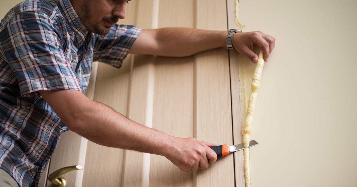 worker cutting off excess insulation