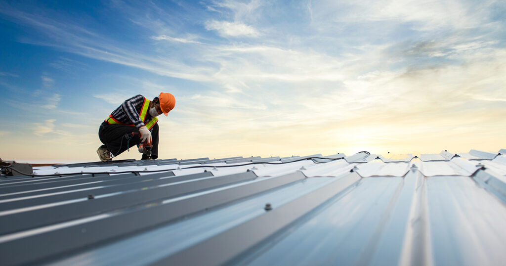 A commercial roofer inspects a commercial roof.