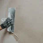Male,Builder,In,Work,Overalls,Plastering,A,Wall,Using,A